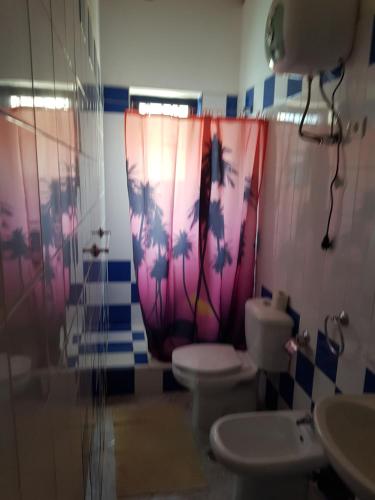 une salle de bain avec deux toilettes et un rideau de douche dans l'établissement Casa Azul SANTA MARIA Cape Verde, à Santa Maria