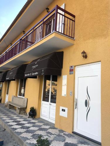 a building with a white door and a balcony at Marqueses de Ferreira in Lamas de Ferreira
