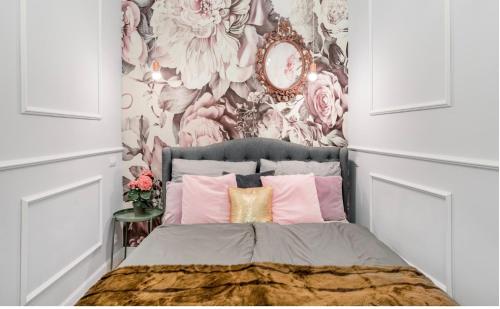 a bedroom with a bed with a floral wallpaper at Vogue apartment near by Wenceslas Square in Prague