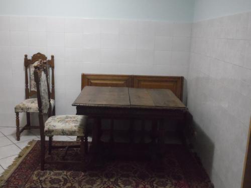 una mesa de madera y 2 sillas en una habitación en Piazza Castello, en Candelo