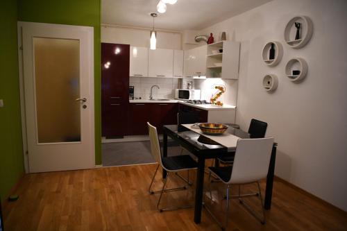 uma cozinha com mesa e cadeiras num quarto em Oaza Green - Apartman Arena Zagreb em Zagreb