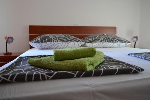 łóżko z zielonym ręcznikiem na górze w obiekcie Apartment Din w mieście Banjole