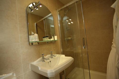 a bathroom with a sink and a mirror at The Craven Heifer Inn in Kelbrook
