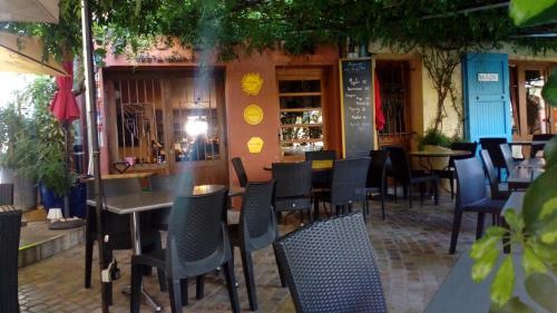 un restaurant avec des tables et des chaises devant un bâtiment dans l'établissement Maison au pied de la cathédrale, à Elne