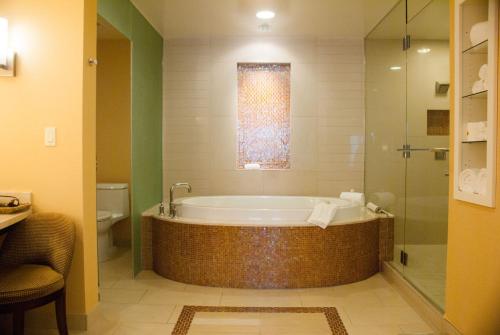 La salle de bains est pourvue d'une baignoire et d'une douche en verre. dans l'établissement Agua Caliente Casino Rancho Mirage, à Rancho Mirage