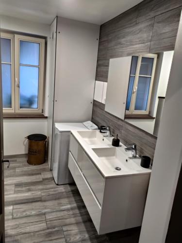 a bathroom with two sinks and two mirrors at La Grande Terrine - Gîtes Les Potiers in Kaysersberg
