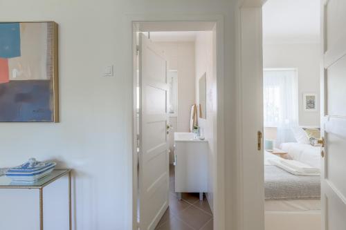 a white hallway with a door leading to a bedroom at Sunny, Bright and Quiet Apartment, By TimeCooler in Lisbon