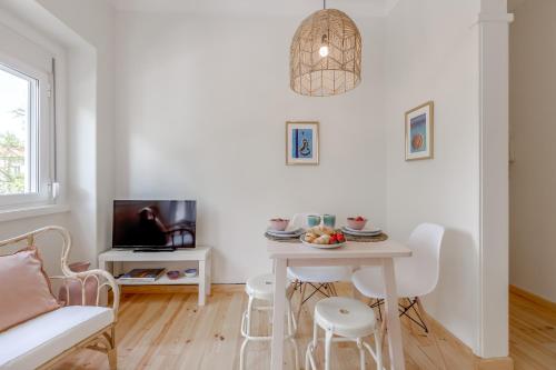 a white living room with a table and a couch at Sunny, Bright and Quiet Apartment, By TimeCooler in Lisbon