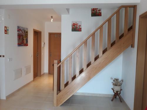 a staircase in a home with white walls and wooden railings at Praia do Pedrógão in Pedrógão