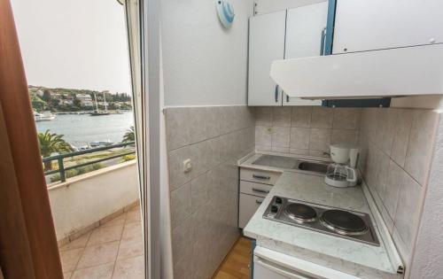 a small kitchen with a view of the water at Apartments Mare - 30m from beach in Seget Vranjica