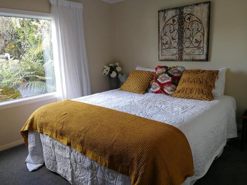 1 dormitorio con cama y ventana en Mont's Cottage en Awatuna