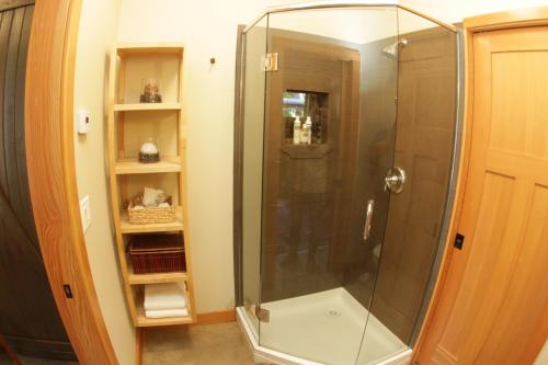 a shower with a glass door in a bathroom at Black Bear Guesthouse in Tofino