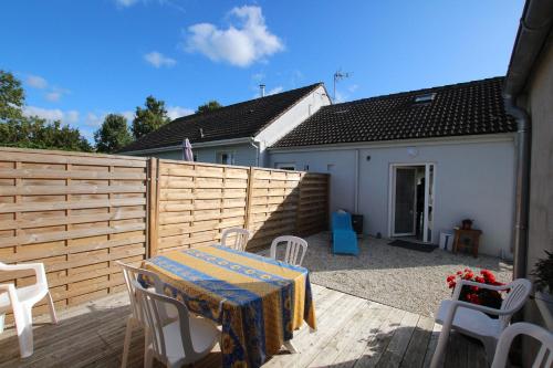 a patio with a table and chairs and a fence at La Roseraie in Yvetot Bocage