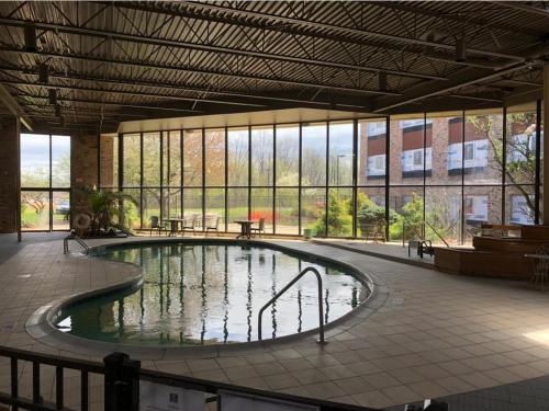 una gran piscina de agua en un edificio con ventanas en Ramada by Wyndham Michigan City en Michigan City