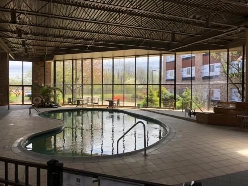 - une grande piscine d'eau dans un bâtiment avec fenêtres dans l'établissement Ramada by Wyndham Michigan City, à Michigan City