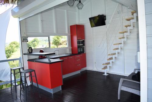 a kitchen with red cabinets and a staircase at Bungalow la paillote in Le François
