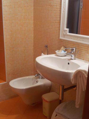 a bathroom with a sink and a mirror and a toilet at Terme Di Monte Valenza in Valenza