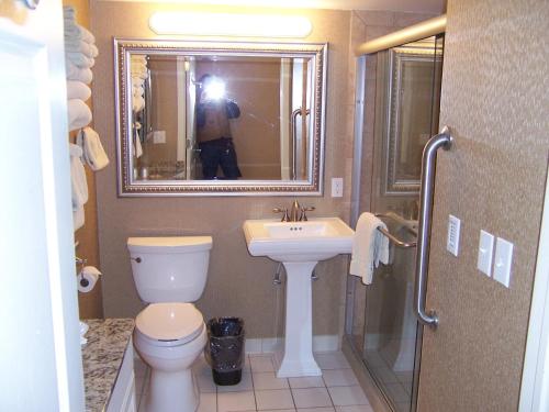 un homme prenant une photo d'une salle de bains avec toilettes et lavabo dans l'établissement Pinestead Reef Resort, à Traverse City