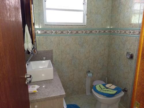 a bathroom with a toilet and a sink and a window at Casa de Praia in Governador Celso Ramos