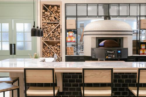 a kitchen with a counter with chairs and a oven at Best Western Plus Baker Street Inn in Nelson