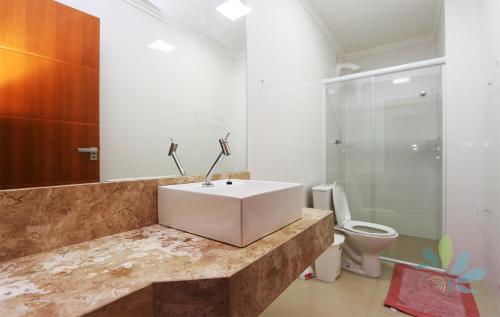 a bathroom with a sink and a toilet at Residencial Bela Morada in Torres