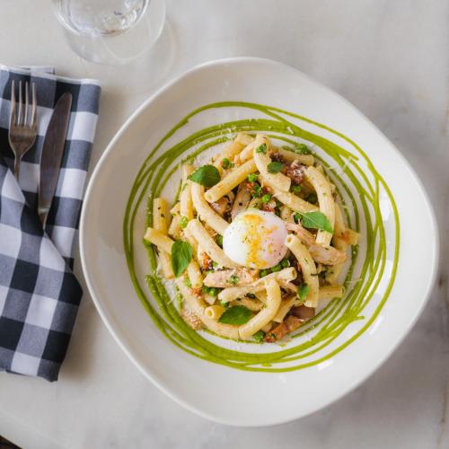 a plate of pasta with an egg on a table at Best Western Plus Baker Street Inn in Nelson