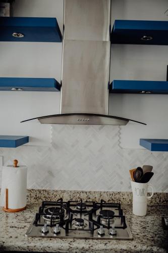 a kitchen with a stove top with a hood at Trojan House in Ensenada