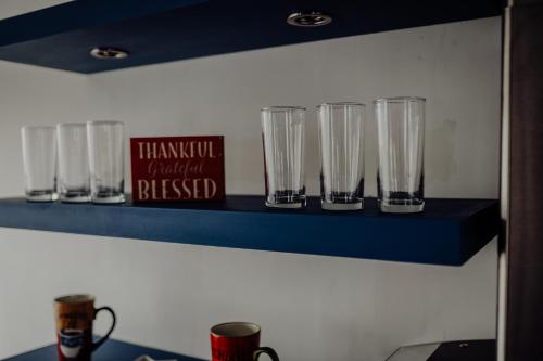 a shelf with several empty glasses on it at Trojan House in Ensenada