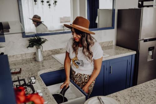 a woman in a hat standing in a kitchen at Trojan House in Ensenada