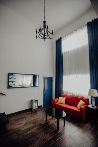 a living room with a red couch and blue curtains at Trojan House in Ensenada