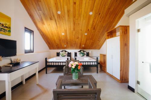 a room with two beds and a table with flowers at Hoi An Lotus Aroma Villa in Hoi An