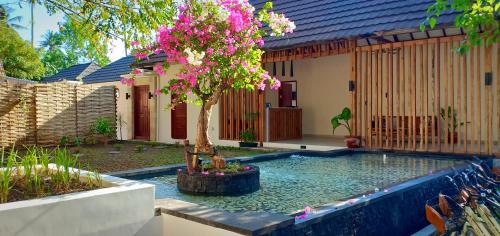 a swimming pool with a tree in front of a house at Ke Rensia Private Pool Villas Gili Air in Gili Islands