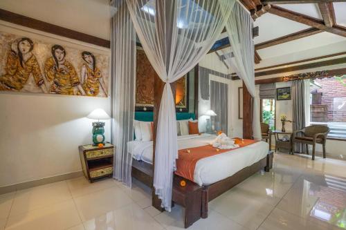a bedroom with a bed and a painting on the wall at KTS Balinese Villas in Canggu