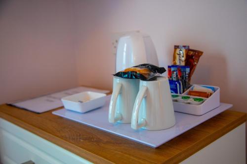 a counter with two white utensils on a shelf at Carmel House in Llandudno