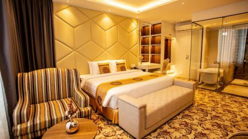 ELIZABETH HOTEL في Thu Dau Mot: غرفه فندقيه بسرير وكرسي