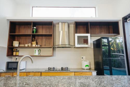 a kitchen with wooden cabinets and a sink at Hoi An Lotus Aroma Villa in Hoi An