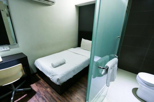 Habitación pequeña con cama y aseo en Hotel 99 Bandar Klang (Meru), en Klang