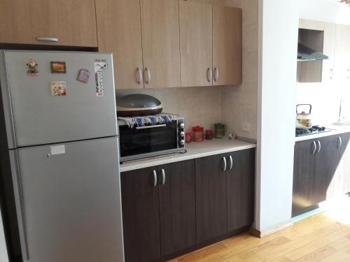 een keuken met een koelkast en een magnetron bij For our friends Center 2 bedrooms in Baku