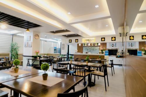 un restaurante con mesas y sillas y una cocina en The Horizon Suites and Arcade, en General Santos