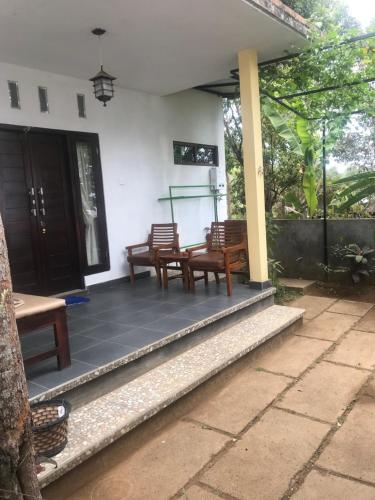 a porch of a house with chairs and a table at Sugi Gede Homestay in Singaraja