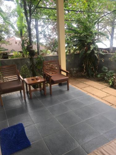 a patio with two chairs and a table at Sugi Gede Homestay in Singaraja