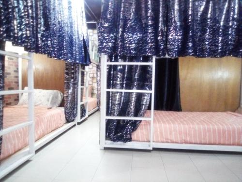 a room with two bunk beds and blue curtains at Ban Kru Ae mixed dorm in Ban Don Muang
