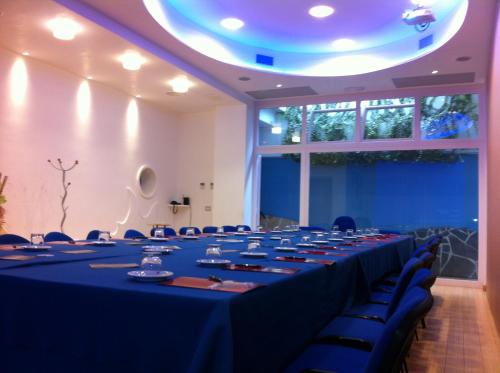 a conference room with a long table with blue tables and chairs at Hotel d'Altavilla in Canosa di Puglia