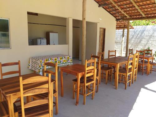 eine Gruppe von Holztischen und -stühlen in einem Zimmer in der Unterkunft Villa Portal dos Ventos in Fortim