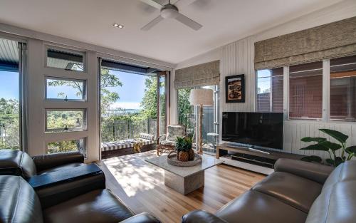 a living room with couches and a large television at Noosa Residences in Noosa Heads