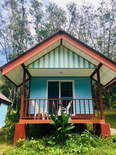 a blue house with a porch and two chairs on it at Mookies Bungalows in Koh Mook