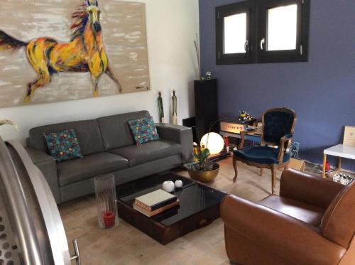 a living room with a couch and a horse painting on the wall at Chambre Zen King Size in Pierrelatte