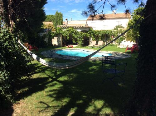 a hammock in a yard next to a swimming pool at Chambre Zen King Size in Pierrelatte