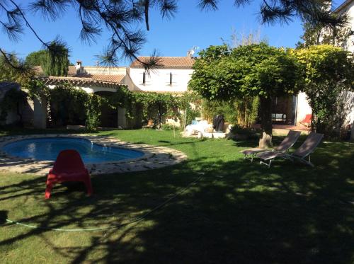 a yard with two chairs and a swimming pool at Chambre Zen King Size in Pierrelatte