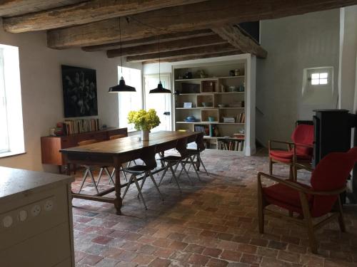 ein Esszimmer mit einem Holztisch und Stühlen in der Unterkunft Orangerie du chateau de Quemigny sur Seine in Quemigny-sur-Seine